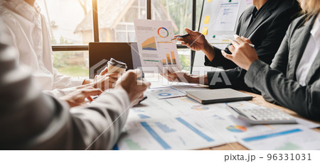 Business documents on office table with smart phone and calculator digital tablet and graph business with social network diagram and two colleagues discussing data working in the office.. 96331031