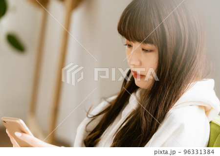 スマホを見て疲れを感じる若い女性 スマホを見て疲れを感じる若い女性 96331384