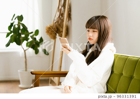 スマホを見て疲れを感じる若い女性 スマホを見て疲れを感じる若い女性 96331391