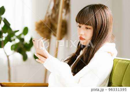 スマホを見て疲れを感じる若い女性 スマホを見て疲れを感じる若い女性 96331395