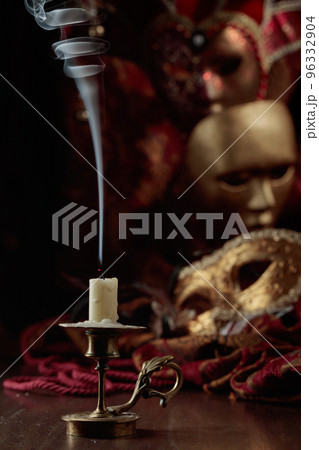 Still life with an extinguished candle and carnival masks. 96332904