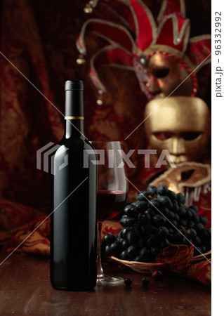 Red wine, grapes, and vintage carnival masks. 96332992