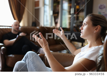 Female client taking with professional psychologist during psychotherapy session. Female client taking with professional psychologist during psychotherapy session. 96333456