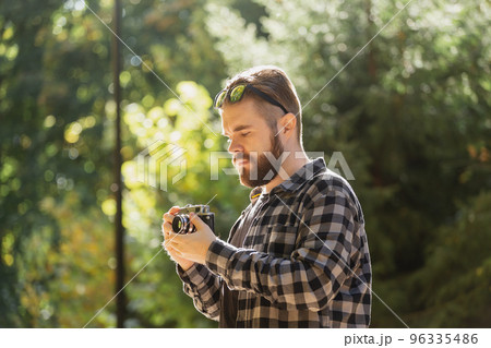 Man photographer taking picture with vintage camera on city green park copy space and place for text - leisure activity and hobby concept 96335486