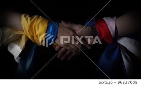 Russian flag and Ukrainian flag on a black background. Russian flag and Ukraine flag in hands showing symbol of struggle war political struggle political expressions Civil wars and territory conflict. 96337008