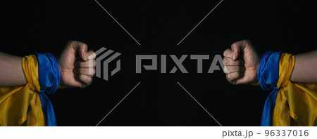 Russian flag and Ukrainian flag on a black background. Russian flag and Ukraine flag in hands showing symbol of struggle war political struggle political expressions Civil wars and territory conflict. 96337016