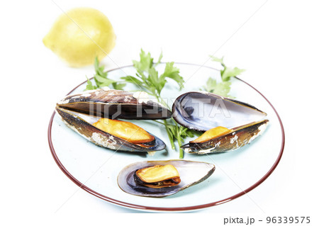 Dish with steamed mussels with parsley and lemon on a white background 96339575