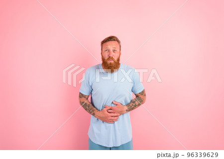 Man with light blue t-shirt has pain in his stomach Man with light blue t-shirt has pain in his stomach 96339629