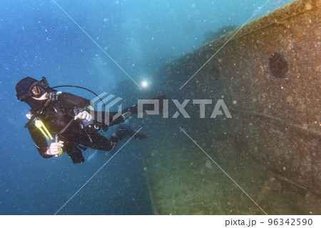 divers exploring a shipwreck underwater 96342590