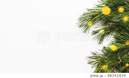 Festive banner with pine tree branches and light bulbs bokeh. White background with copy space and decorations for Christmas and New Year celebration. 96342839