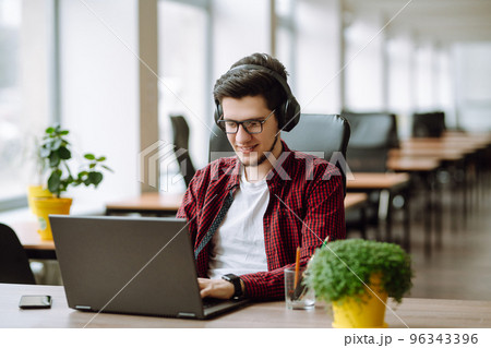 Young man working on laptop. Education and working online. Freelancer, technology, remote job. 96343396