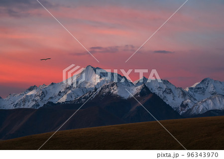 Snowy mountain peaks at dawn. Purple sunset over majestic mountains. Sunset in magenta tones. Atmospheric purple landscape with a high-altitude snowy mountain valley. Snowy mountain peaks at dawn. Purple sunset over majestic mountains. Sunset in magenta tones. Atmospheric purple landscape with a high-altitude snowy mountain valley. 96343970