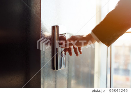 Man pressing elevator button. finger presses the elevator button. Red button. sunset light. 96345246