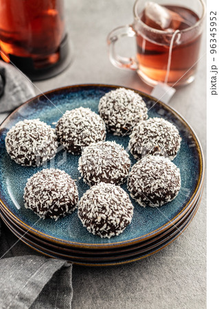 Coconut chocolate balls on plate on kitchen table. Coconut chocolate balls on plate on kitchen table. 96345952