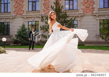 beautiful blonde bride dancing and whirling in front of the groom. beautiful blonde bride dancing and whirling in front of the groom. 96346607
