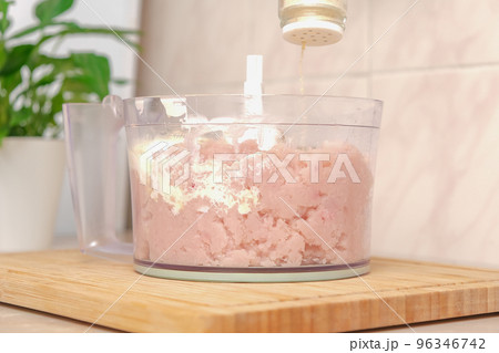 Man adds spices to food processor with chopped Man adds spices to food processor with chopped 96346742