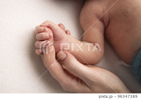 Close-up little hand of child and palm of mother and father. The newborn baby has a firm grip on the parent's finger after birth. A newborn holds on to mom's, dad's finger. Close-up little hand of child and palm of mother and father. The newborn baby has a firm grip on the parent's finger after birth. A newborn holds on to mom's, dad's finger. 96347389