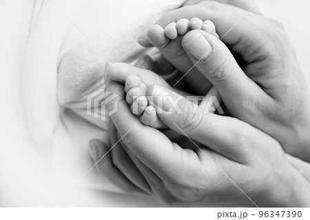 Legs, toes, feet and heels of a newborn. With the hands of parents, father, mother gently holds the child's legs. Macro photography, close-up. Black and white photo. High quality photo Legs, toes, feet and heels of a newborn. With the hands of parents, father, mother gently holds the child's legs. Macro photography, close-up. Black and white photo. High quality photo 96347390