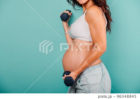 Pregnant woman expecting a child caresses her belly 96348845