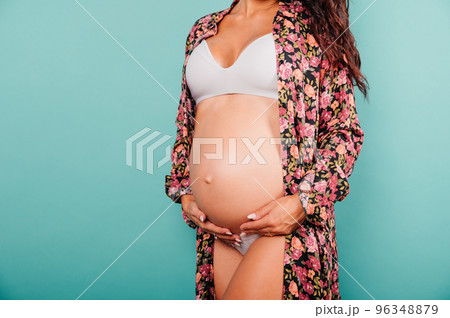 Pregnant woman expecting a child caresses her belly 96348879