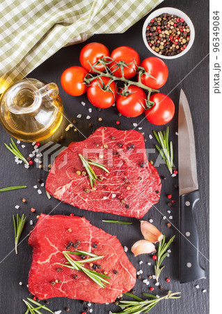 Fresh raw beef steak with spice on black background Fresh raw beef steak with spice on black background 96349084