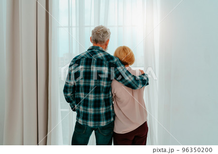 Retired husband and wife hug each other at home 96350200