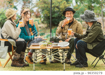 キャンプ場で仲間と一緒にビールを飲んでパーティーするアジア人の男女 96350279
