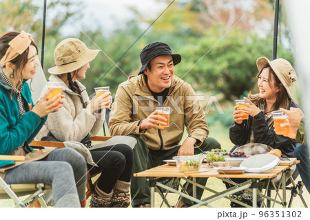 秋冬のキャンプ場で仲間と一緒にビールを飲んでパーティーするアジア人の男女 秋冬のキャンプ場で仲間と一緒にビールを飲んでパーティーするアジア人の男女 96351302