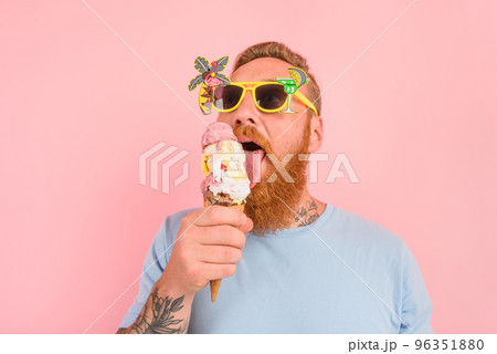 Hungry man with beard and tattoos eats a big icecream 96351880