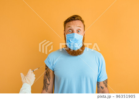 Afraid man with beard, tattoo and mask for covid-19 is ready for the virus vaccine 96351905