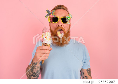 Hungry man with beard and tattoos eats a big icecream 96352007