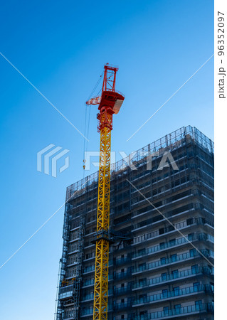 建設中の高層マンション そびえるクレーンと快晴の空 タテ 建設中の高層マンション そびえるクレーンと快晴の空 タテ 96352097