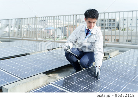 ソーラーパネルを点検する男性作業員 96352118
