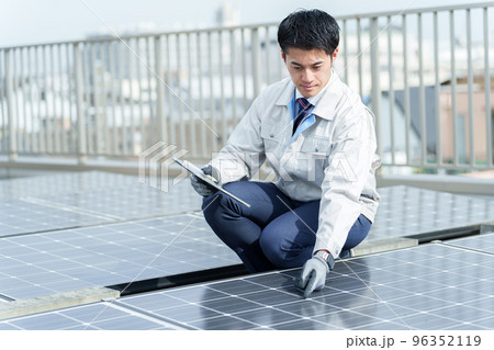 ソーラーパネルを点検する男性作業員 ソーラーパネルを点検する男性作業員 96352119