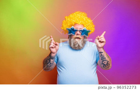 Fat thoughtful man with beard, tattoos and sunglasses dances music on a disco 96352273
