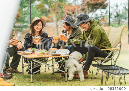 秋冬のキャンプ場で犬と遊ぶアジア人の男女 96353000