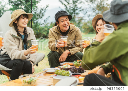 秋冬のキャンプ場で仲間と一緒にビールを飲んでパーティーするアジア人の男女 96353003