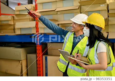 Professional adult Asian male warehouse manager and female worker are working together Professional adult Asian male warehouse manager and female worker are working together 96353351