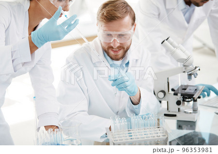 laboratory staff comparing liquid in laboratory tubes . 96353981