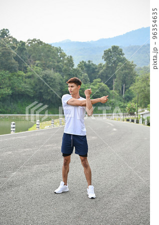 Handsome fit Asian athletic man stretching his arms, warming up before exercise 96354635