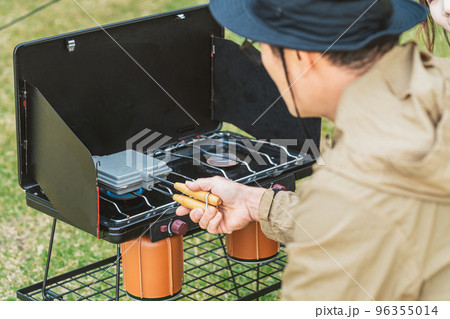 秋冬のキャンプでキャンプ飯のホットサンドを作るアジア人キャンパー 96355014