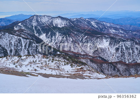 冬の日光白根山 登山道2500m付近から下る登山者と南西側の山々(錫ヶ岳,黒桧山など)を見る 96356362