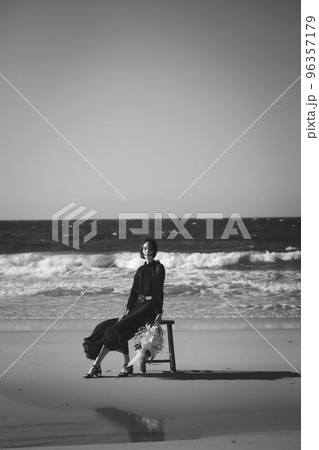 海辺で椅子に座る女性 96357179