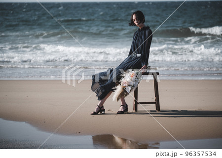 海辺で椅子にブーケを持って座る女性 96357534