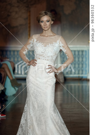 Attractive fashion model in wedding dress on stage in spotlight Attractive fashion model in wedding dress on stage in spotlight 96360532