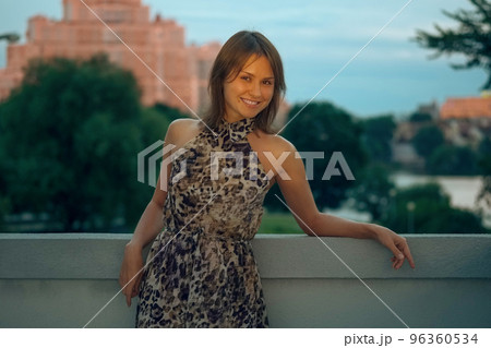 Laughing woman on balcony at sunset Laughing woman on balcony at sunset 96360534