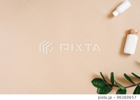 Organic cosmetics with a green branch of zamiokulkas and bottles of creams on a beige background with a copy of the space, top view and flat lay 96360657