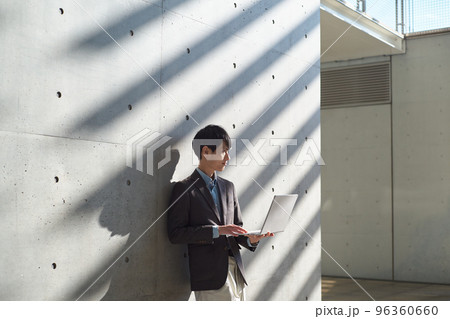 立ちながらパソコンを操作する男性 立ちながらパソコンを操作する男性 96360660