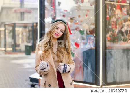 A happy young beautiful girl holds sparklers outdoors at a Christmas and New Year's fair or festival. 96360726