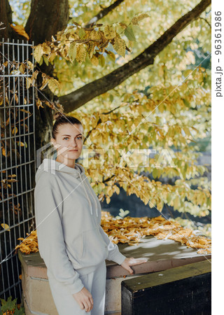 Beautiful elegant woman standing in autumn park with yellow leaves outdoor. Beauty Romantic Girl Outdoors enjoy autumn yellow leaves. Portrait of joyful woman in park during fall. Happy ng nature. Sun 96361986